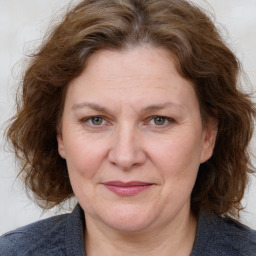 Joyful white adult female with medium  brown hair and blue eyes