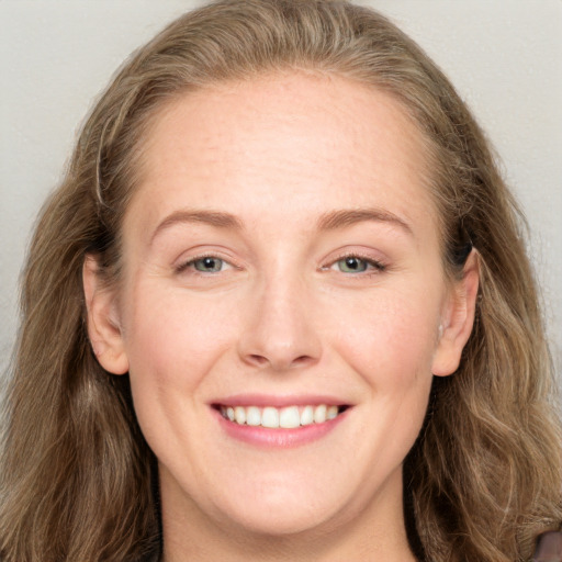 Joyful white adult female with long  brown hair and blue eyes