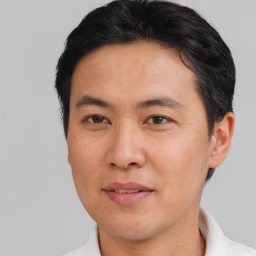 Joyful asian adult male with short  brown hair and brown eyes