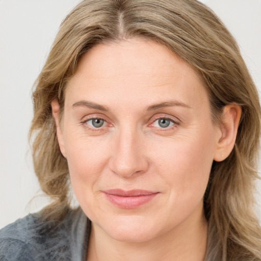 Joyful white adult female with medium  brown hair and blue eyes