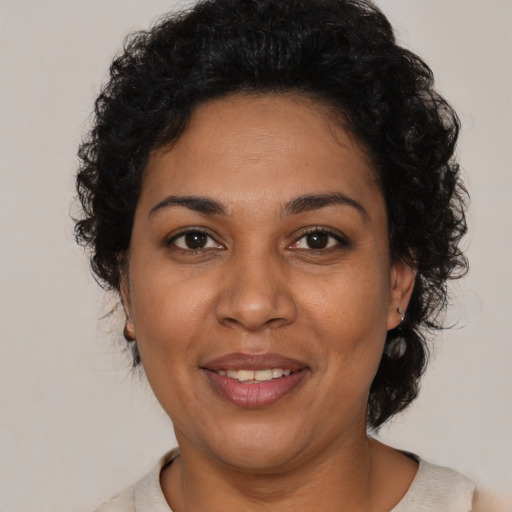 Joyful latino adult female with short  brown hair and brown eyes