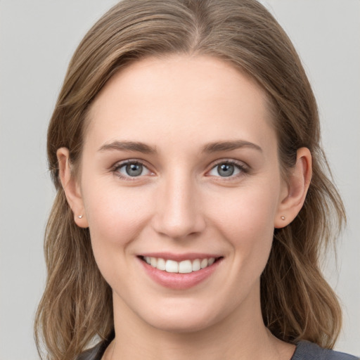 Joyful white young-adult female with long  brown hair and grey eyes