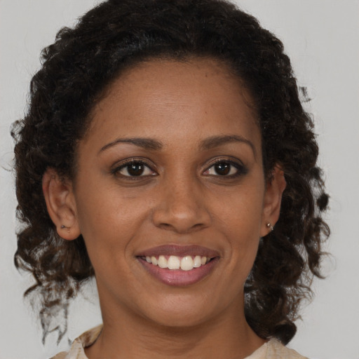 Joyful black young-adult female with medium  brown hair and brown eyes