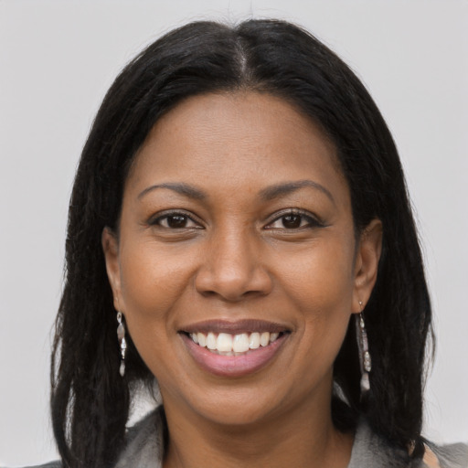 Joyful black young-adult female with long  brown hair and brown eyes