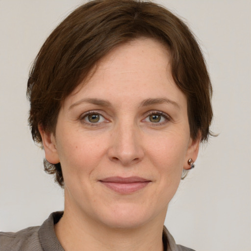 Joyful white adult female with medium  brown hair and grey eyes