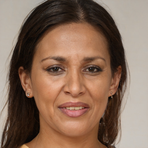 Joyful latino adult female with medium  brown hair and brown eyes