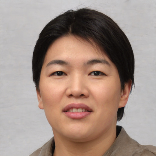 Joyful asian young-adult female with short  black hair and brown eyes