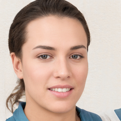 Joyful white young-adult female with short  brown hair and grey eyes