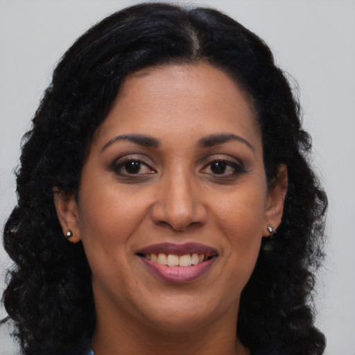 Joyful black young-adult female with long  brown hair and brown eyes