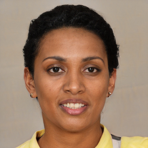 Joyful black young-adult female with short  black hair and brown eyes