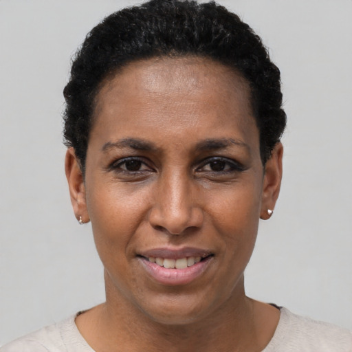 Joyful black young-adult female with short  black hair and brown eyes