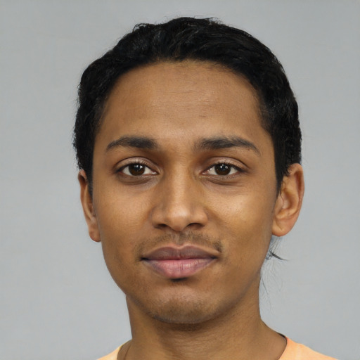 Joyful black young-adult male with short  black hair and brown eyes