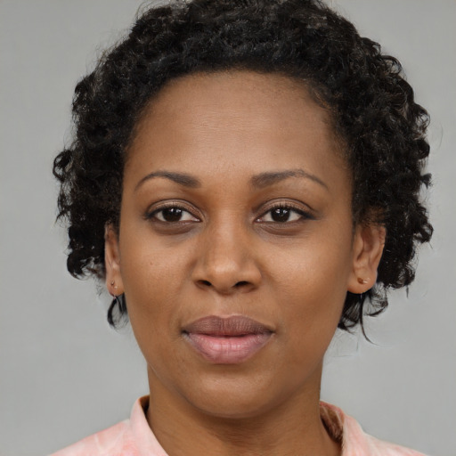 Joyful black young-adult female with medium  brown hair and brown eyes
