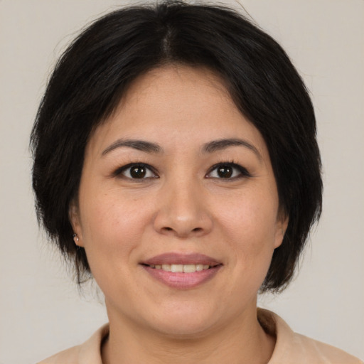 Joyful asian adult female with medium  brown hair and brown eyes