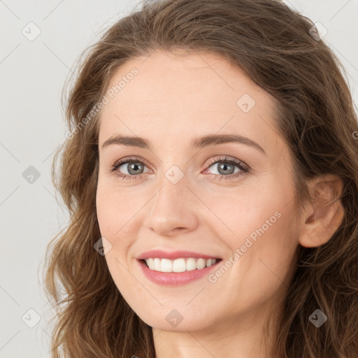 Joyful white young-adult female with long  brown hair and green eyes