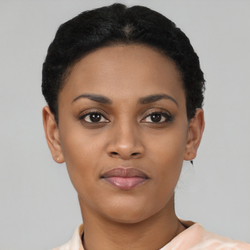 Joyful black young-adult female with short  black hair and brown eyes