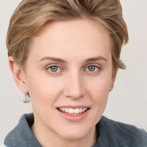 Joyful white young-adult female with short  brown hair and blue eyes