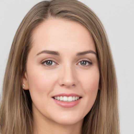 Joyful white young-adult female with long  brown hair and grey eyes