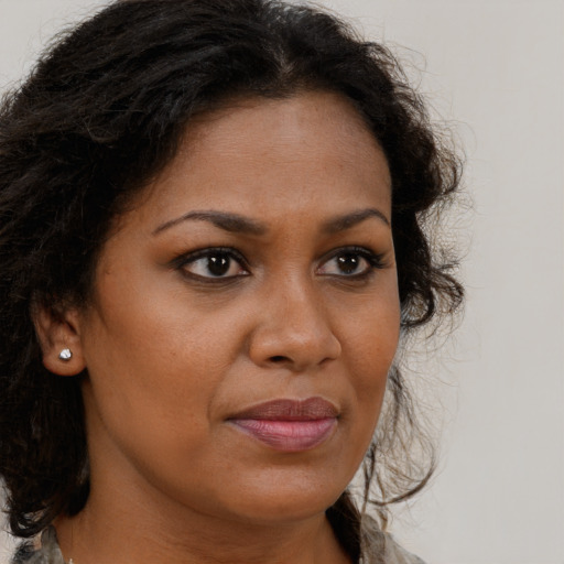 Joyful black young-adult female with long  brown hair and brown eyes