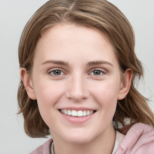 Joyful white young-adult female with medium  brown hair and blue eyes