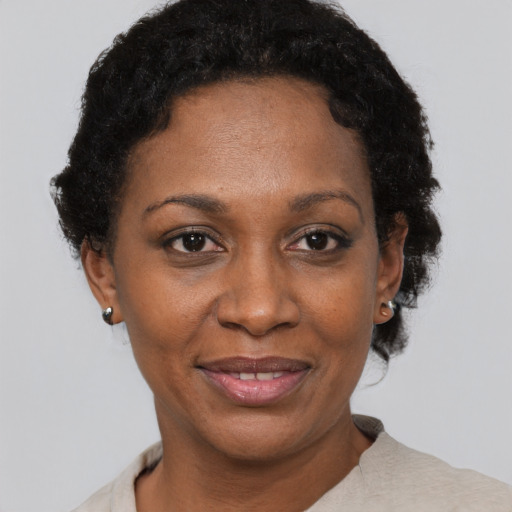 Joyful black adult female with short  black hair and brown eyes