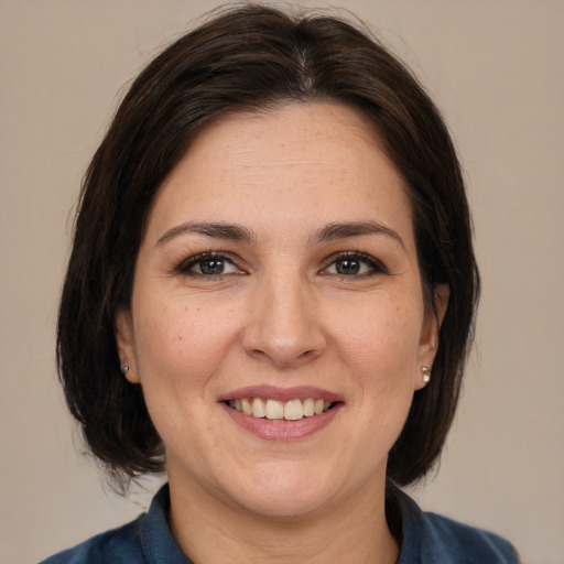 Joyful white adult female with medium  brown hair and brown eyes