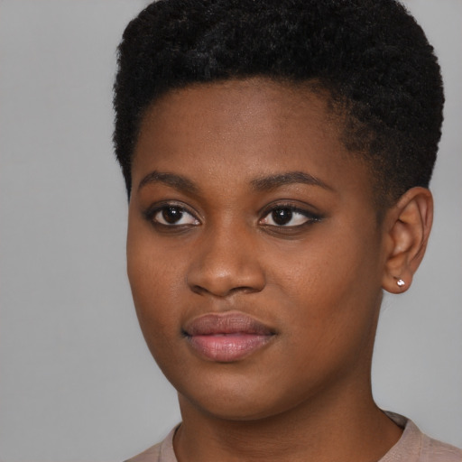 Joyful black young-adult female with short  black hair and brown eyes