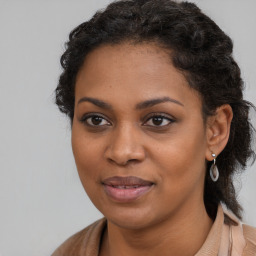 Joyful black young-adult female with long  brown hair and brown eyes