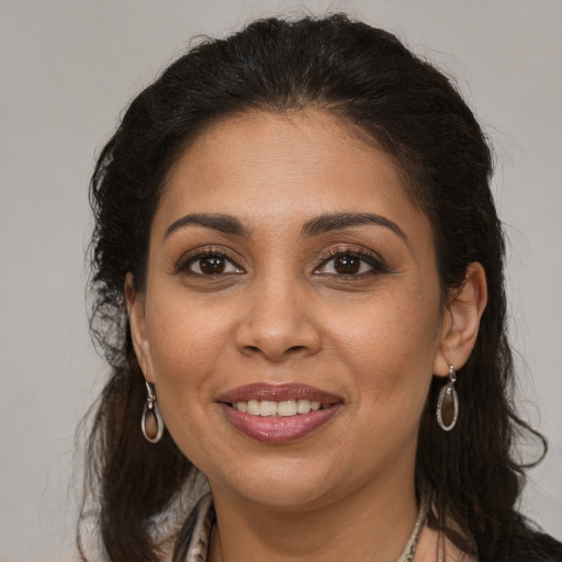 Joyful latino adult female with long  brown hair and brown eyes