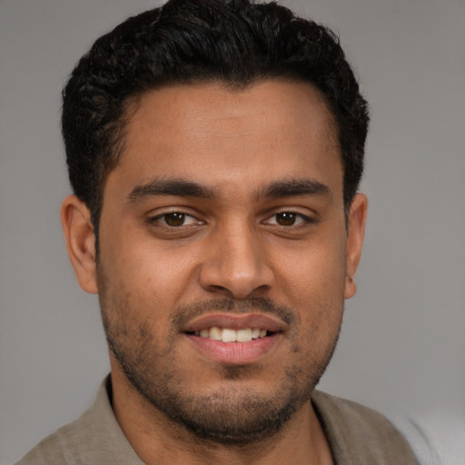 Joyful latino young-adult male with short  brown hair and brown eyes
