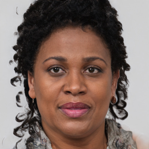 Joyful black adult female with long  brown hair and brown eyes