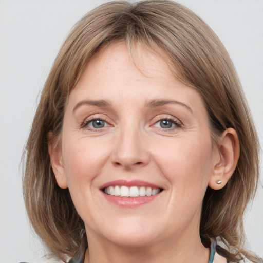 Joyful white adult female with medium  brown hair and grey eyes