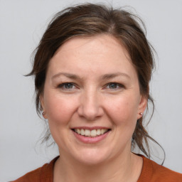 Joyful white adult female with medium  brown hair and grey eyes