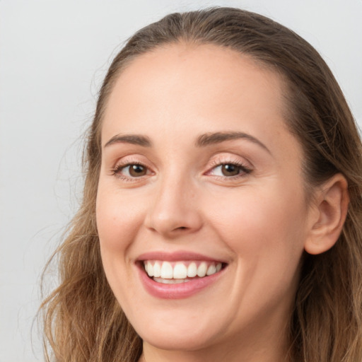 Joyful white young-adult female with long  brown hair and grey eyes