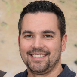 Joyful white adult male with short  black hair and brown eyes