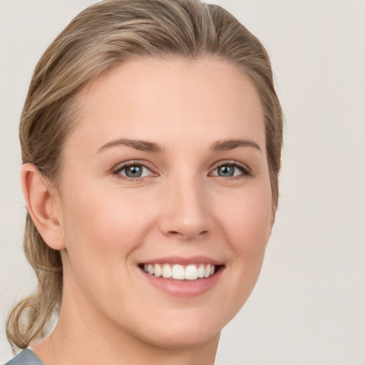 Joyful white young-adult female with medium  brown hair and grey eyes