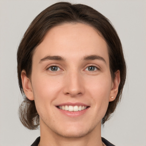 Joyful white young-adult female with medium  brown hair and grey eyes