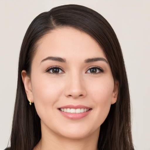 Joyful white young-adult female with long  brown hair and brown eyes