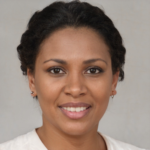 Joyful black young-adult female with short  brown hair and brown eyes