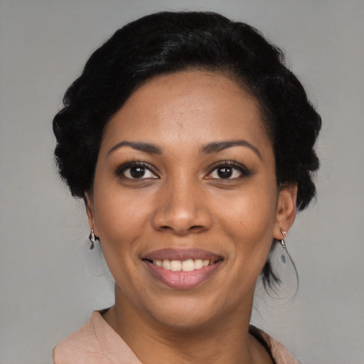 Joyful black young-adult female with short  black hair and brown eyes