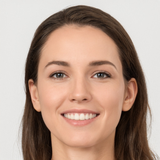 Joyful white young-adult female with long  brown hair and grey eyes