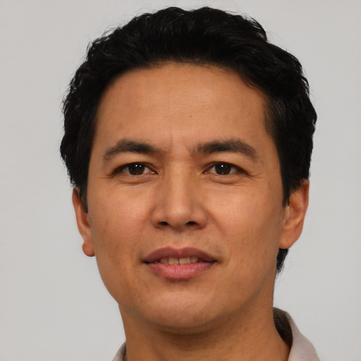 Joyful asian adult male with short  black hair and brown eyes