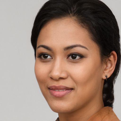Joyful latino young-adult female with short  black hair and brown eyes
