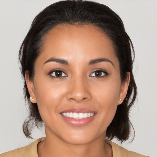 Joyful latino young-adult female with medium  brown hair and brown eyes