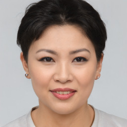 Joyful asian young-adult female with short  brown hair and brown eyes