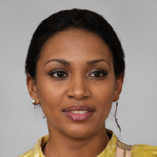 Joyful black young-adult female with short  black hair and brown eyes