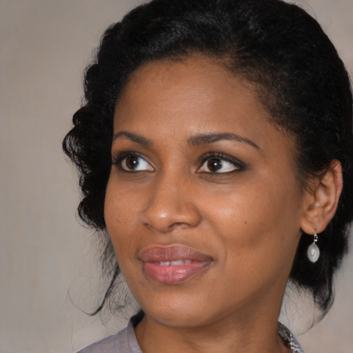 Joyful black young-adult female with medium  black hair and brown eyes