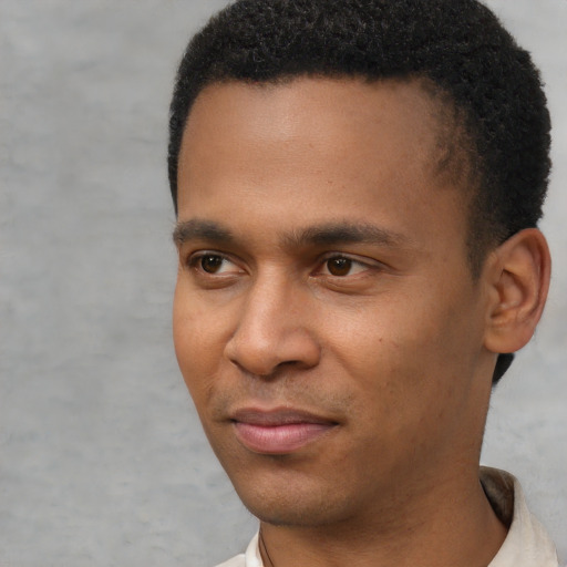 Joyful black young-adult male with short  black hair and brown eyes