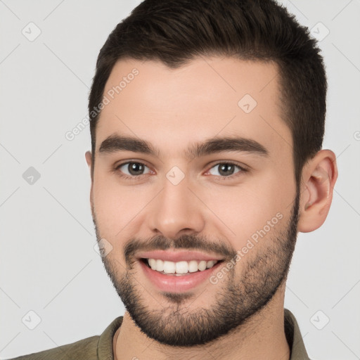 Joyful white young-adult male with short  brown hair and brown eyes