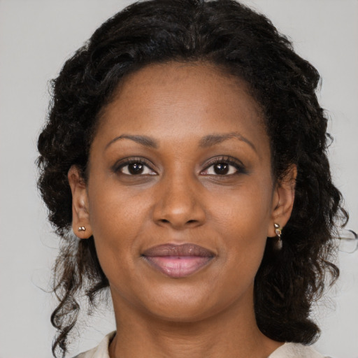 Joyful black adult female with long  brown hair and brown eyes